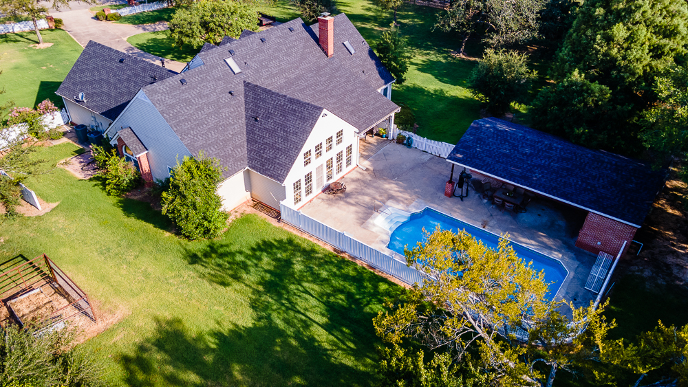 Aerial oblique view of house with a pool